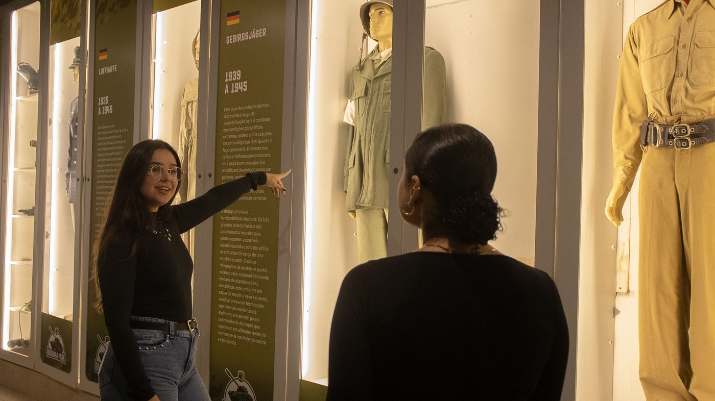 Visitante apresentando os uniformes históricos do acervo